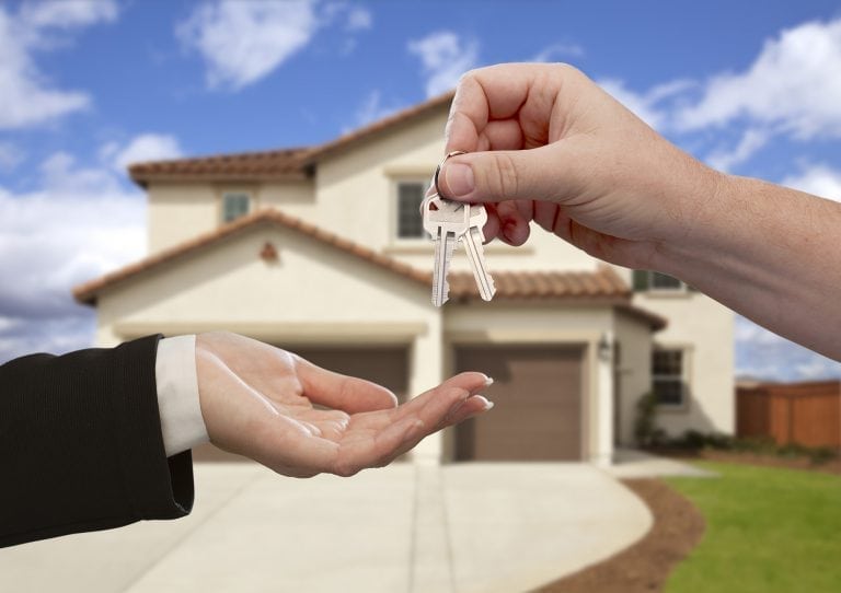 Handing Over the House Keys in Front of New Home